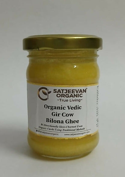 Satjeevan Organic Vedic Gir Cow Bilona Ghee in traditional glass jar with golden-yellow ghee visible inside.