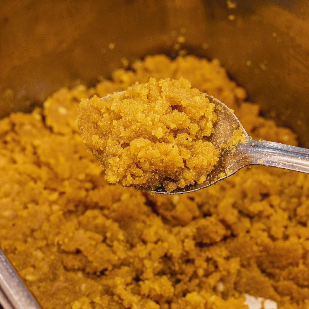 Shree Mithai Moong Dhal Halwa, a bowl of rich North Indian sweet with creamy yellow moong dal halwa garnished with nuts.