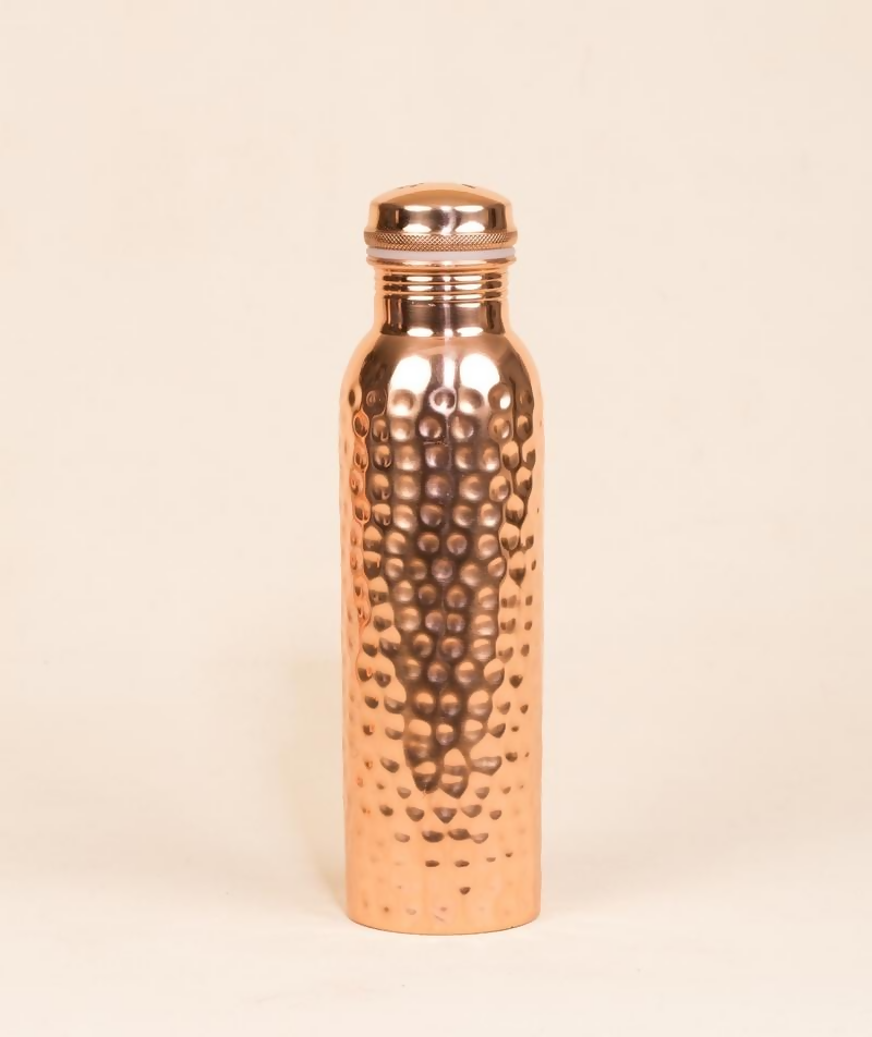 Hammered copper water bottle from Isha Life, 950 ml, showing its textured surface and sleek design for healthy hydration.