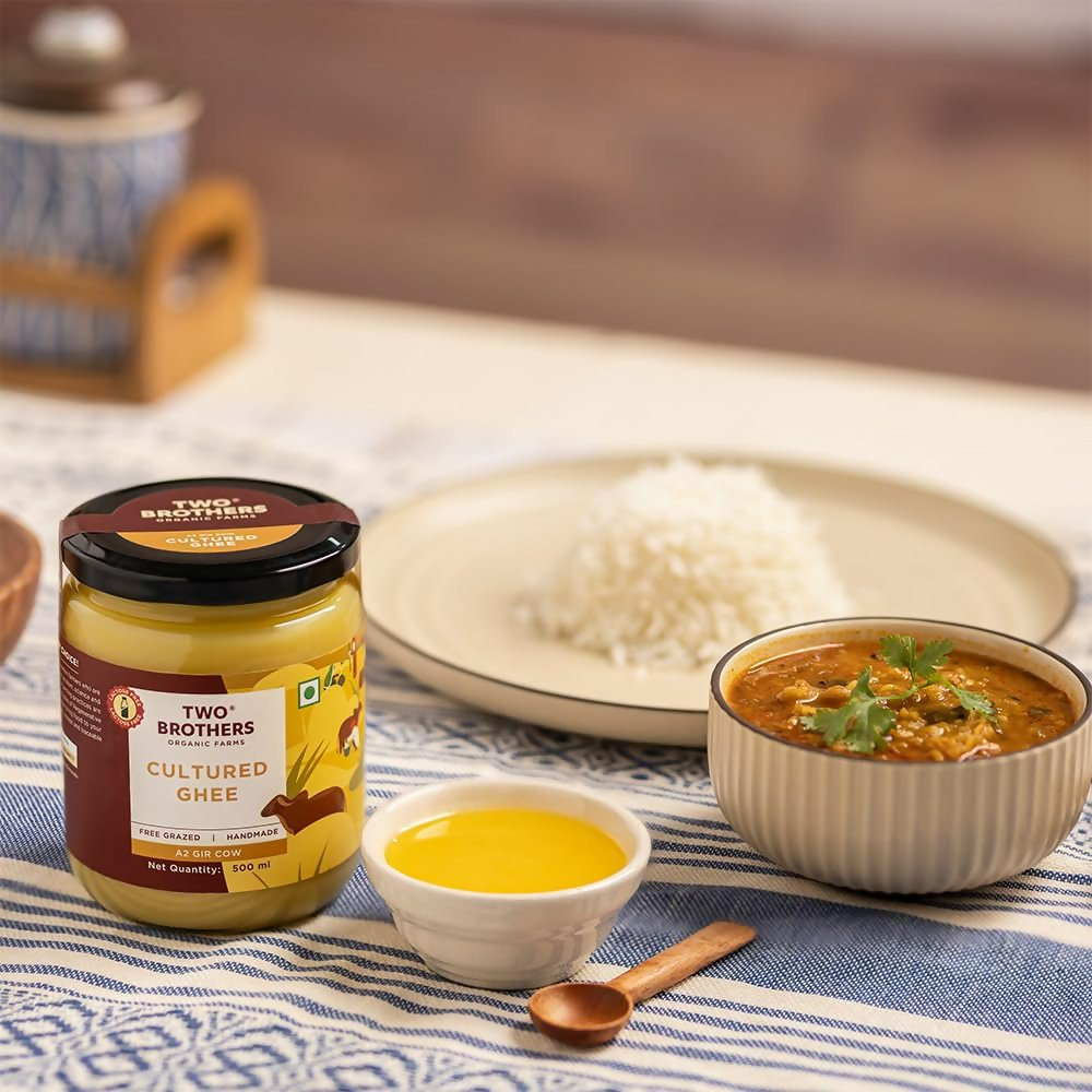 Organic Two Brothers Farms A2 Ghee Butter from grass-fed Gir cows, shown in a clear jar with a golden hue.