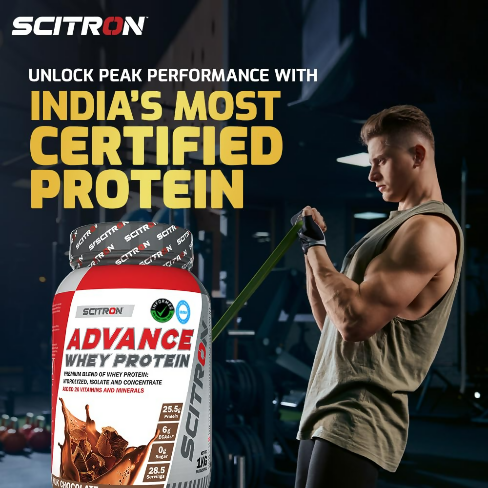 Scitron Advance Whey Protein milk chocolate flavor health drink in a glass with a scoop of powder beside it.